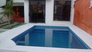 Una piscina al aire libre, sombrillas