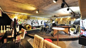Une salle avec une scène, des instruments de musique et un espace bar.