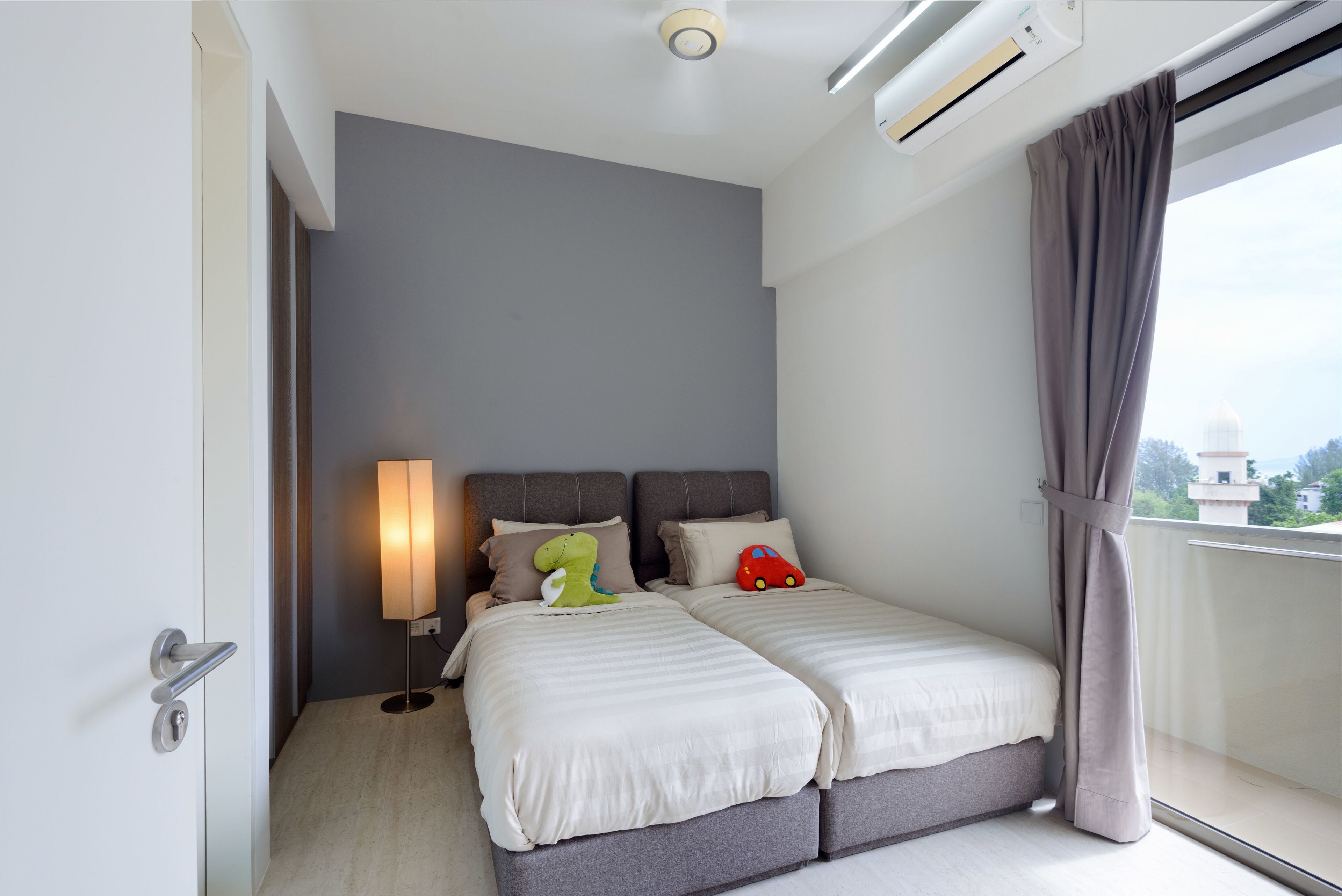 Ein modernes Hotelzimmer mit Bett, Nachttischlampe und Blick auf die Stadt.