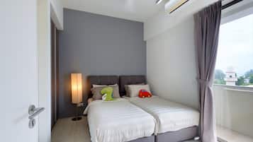 A modern hotel room with a bed, bedside lamp, and a view of the city.