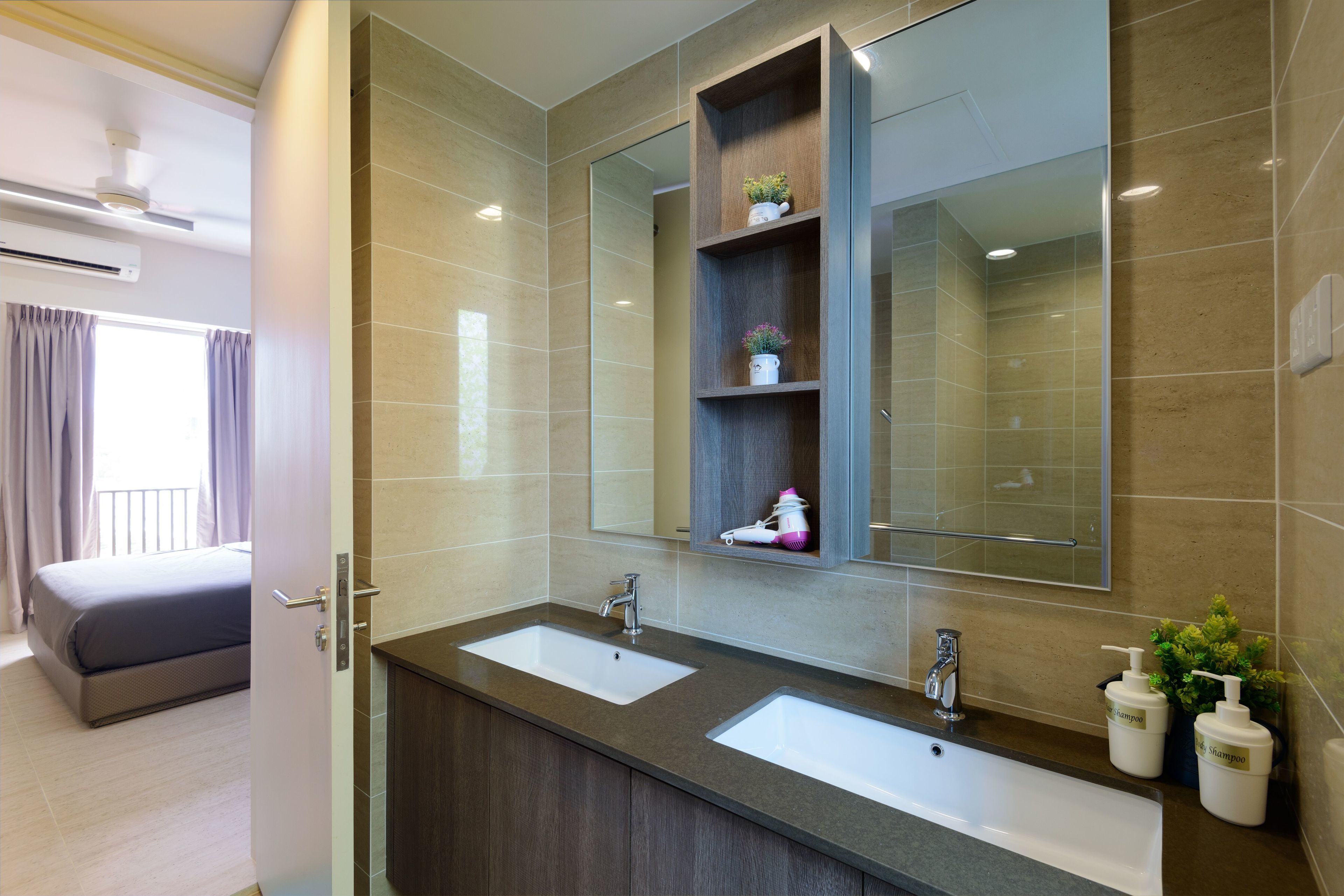 A modern bathroom with two sinks, a large mirror, and a shelf with toiletries.