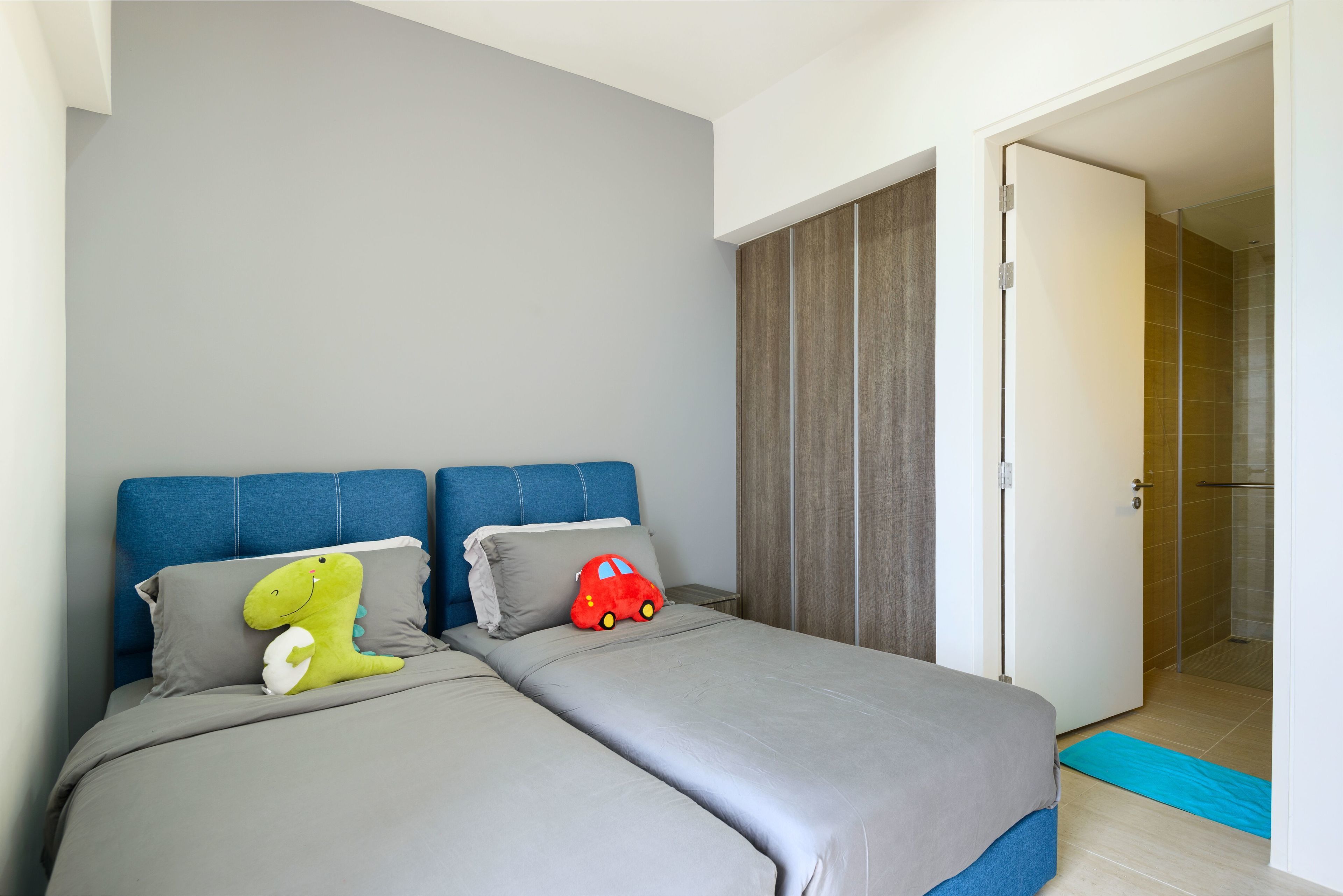A modern bedroom with a bed, pillows, and a toy car.