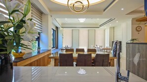 A modern dining area with a round table, chairs, and a chandelier. - Monet Garden B&B (Wujie)