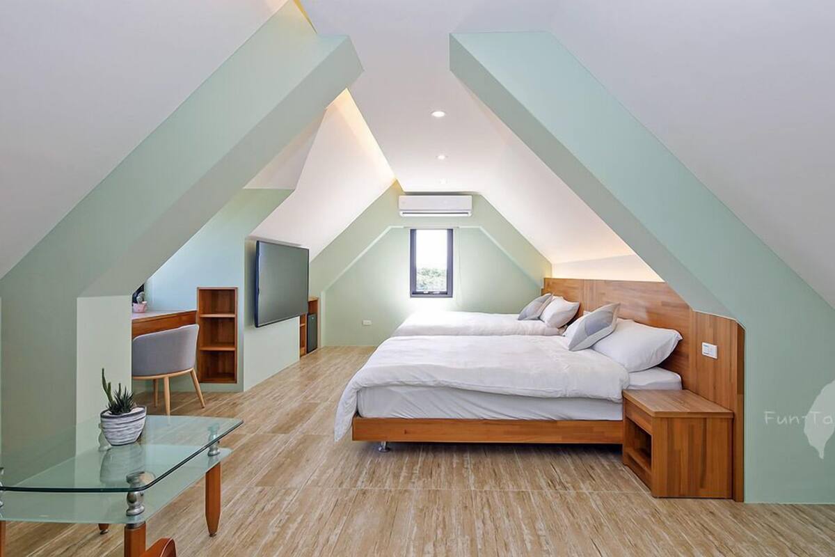 Un dormitorio moderno con diseño estilo loft, que incluye una cama grande, un escritorio y un televisor.
