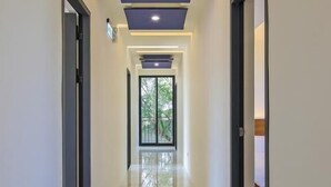 A modern hallway with a reflective floor, recessed lighting, and a large window at the end. - Monet Garden B&B (Wujie)