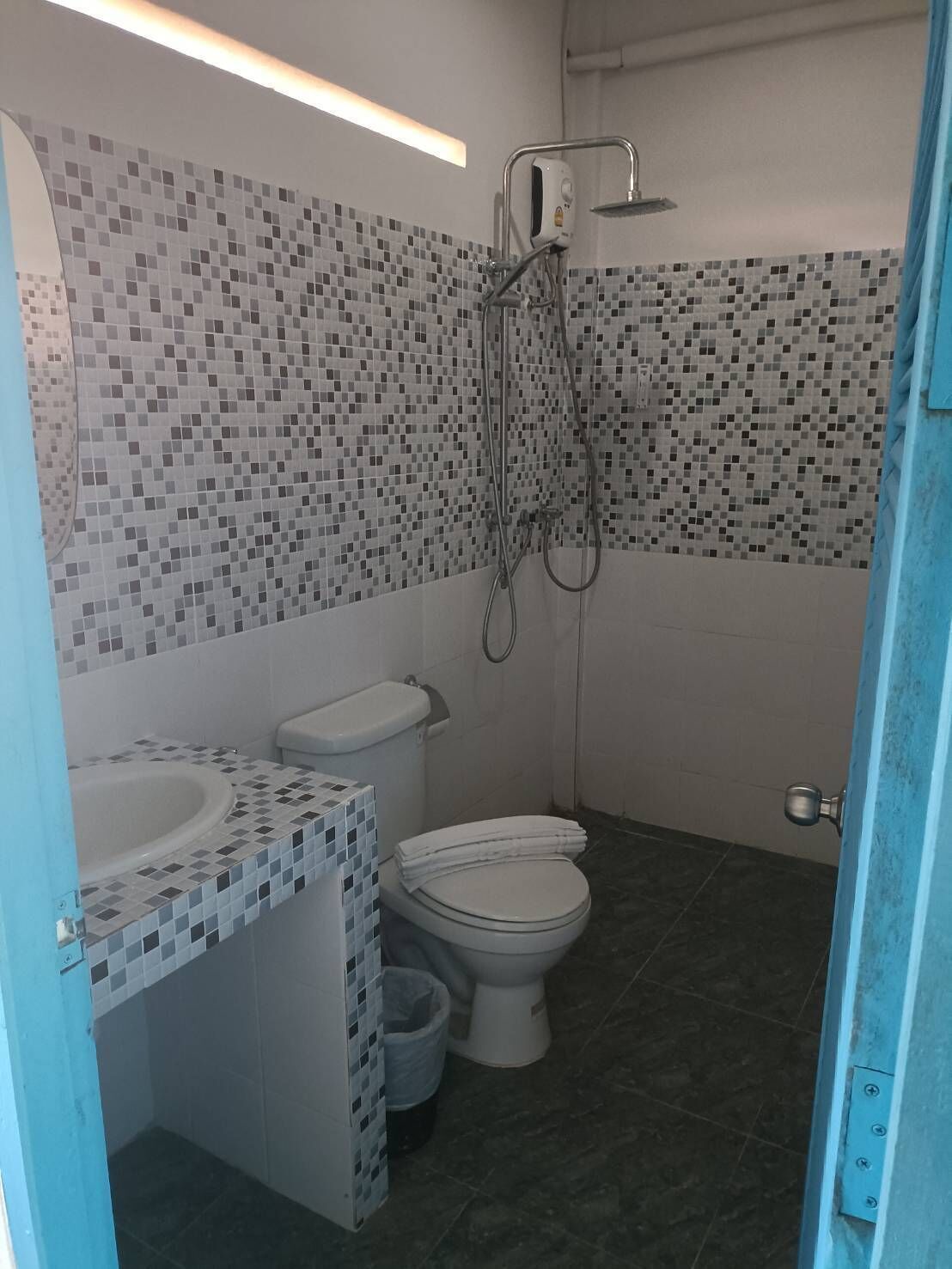 A bathroom with a toilet, sink, and shower.
