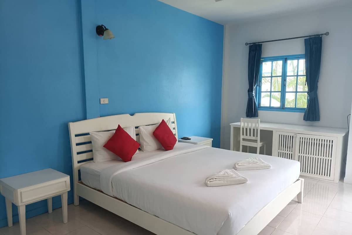Quarto com uma cama, uma mesa e uma cadeira.