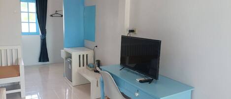A modern room with a blue desk, a television, and a white chair.