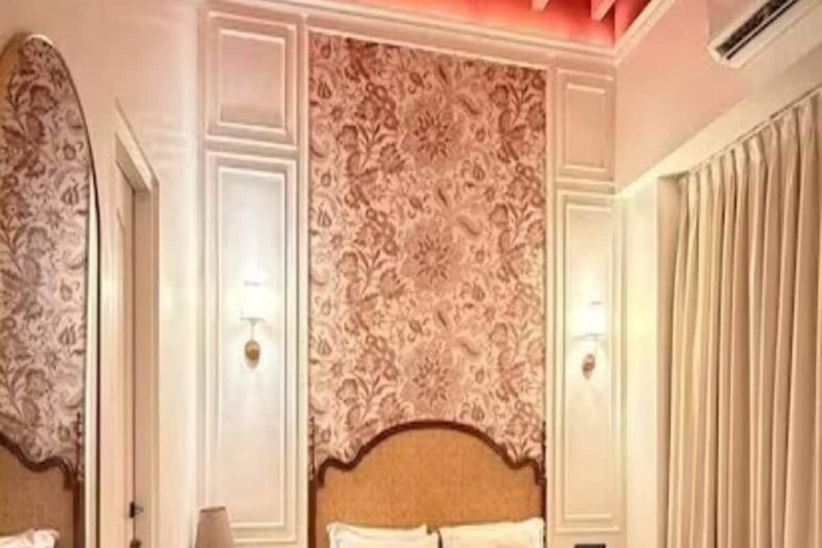A hotel room with a large bed, a nightstand, a lamp, and a ceiling fan.