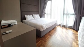 Une chambre d’hôtel moderne avec un grand lit, une table de chevet avec une télécommande et une vue sur l’extérieur à travers des rideaux transparents.