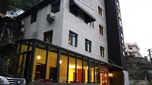 Un edificio de varios pisos con diseño moderno, destacando amplias ventanas y fachada de vidrio.