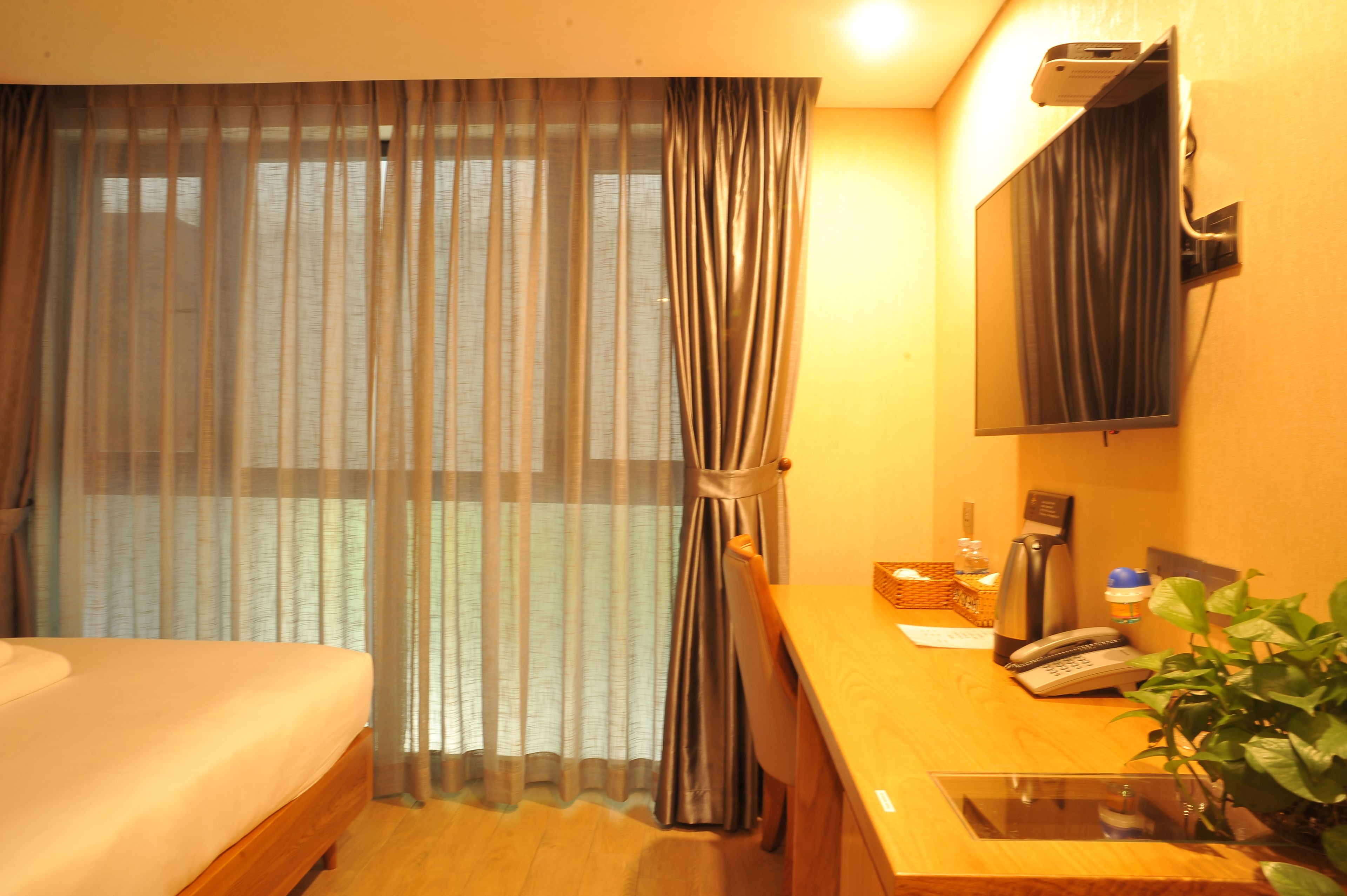 Une chambre d’hôtel équipée d’un lit, d’un bureau avec un téléphone, d’une machine à café et d’un miroir.
