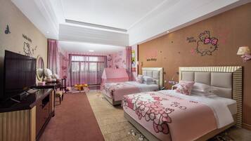 Habitación de hotel con dos camas, televisión, escritorio y ventana grande con cortinas rosadas.