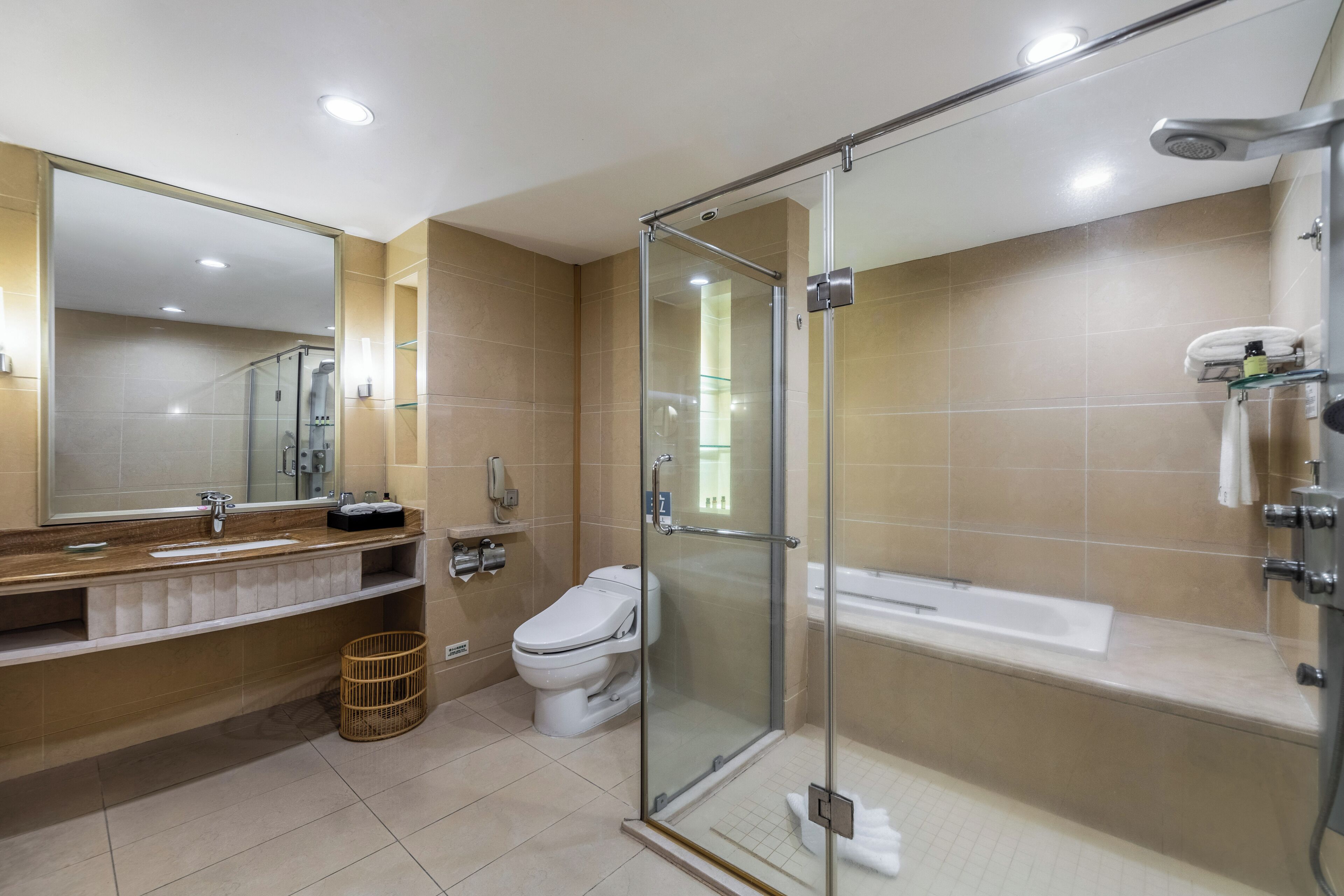 Un baño moderno con ducha de vidrio, un espejo grande y una bañera.