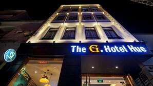 A hotel with a prominent illuminated sign reading "The G. Hotel Hue". - The G.Hotel Hue - Hostel (Hue)