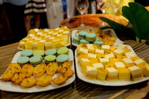 A table with various desserts including macarons and cheese cubes. - The G.Hotel Hue - Hostel (Hue)