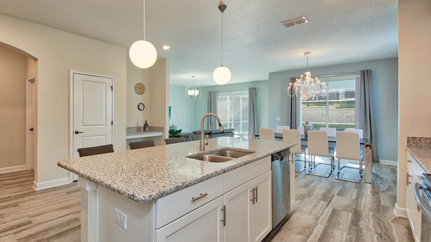 A modern kitchen with a central island, white cabinetry, and a stainless steel sink. - Champions Gate Home 2 U- Maui- Cg1560 (Davenport)