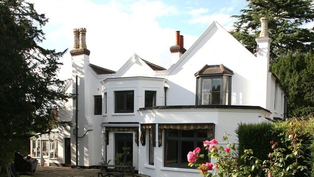 A two-story white building with a garden in front. - West End Lodge (Esher)