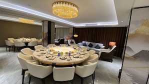 Un espace de restauration moderne avec des tables rondes, des sièges confortables et un éclairage d’ambiance.