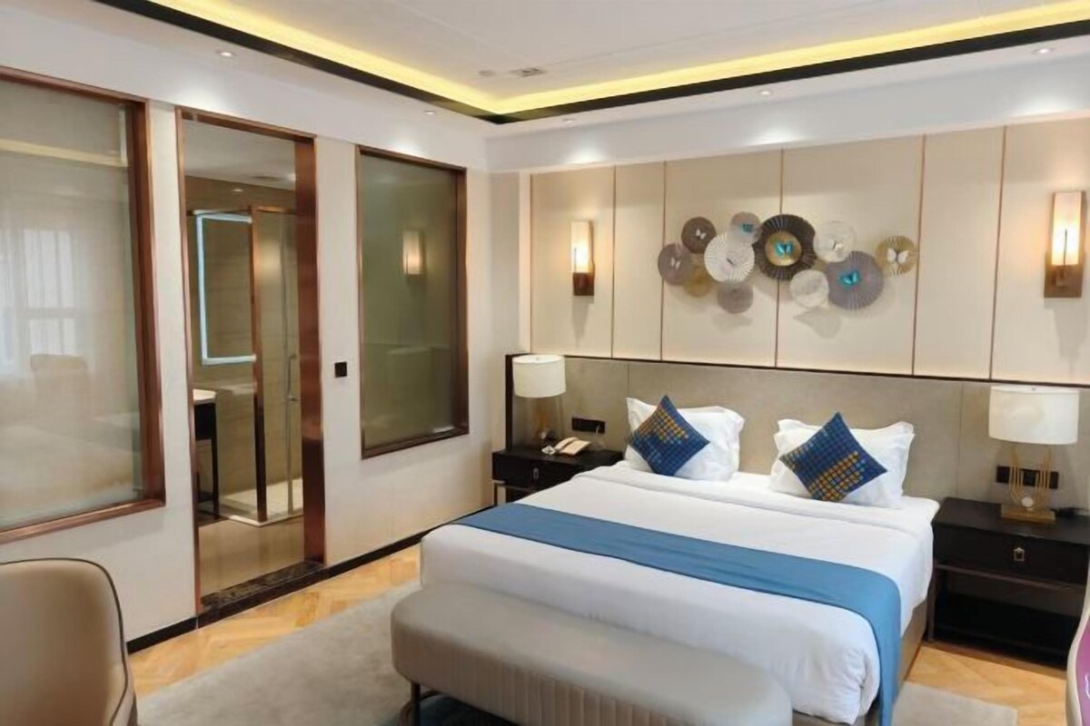 Une chambre d’hôtel dotée d’un grand lit, de tables de chevet, d’un bureau et d’un décor moderne.