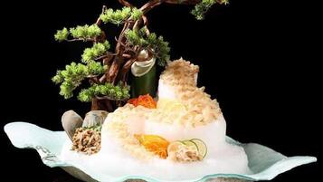 A dessert with a tree and fruits on a plate.