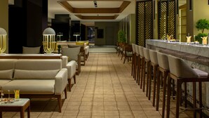 Eine moderne Hotelhalle mit Barbereich, Sofas und Essbereich.
