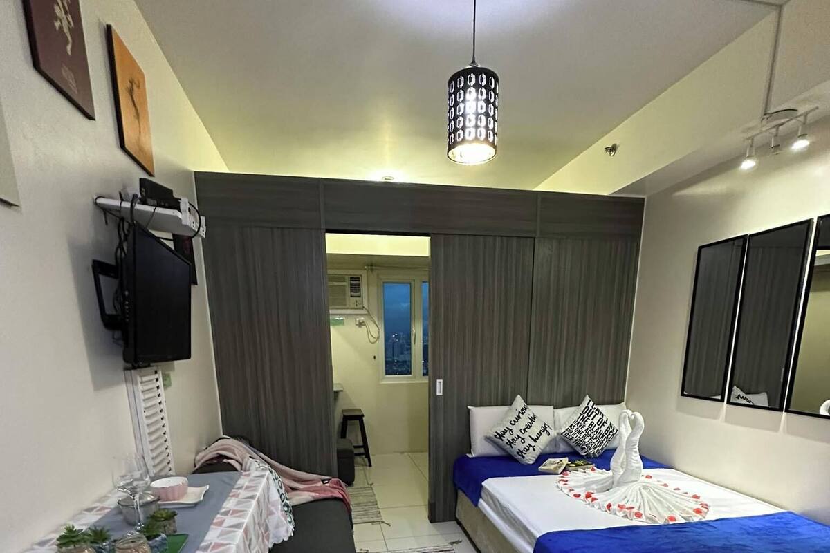Habitación de hotel moderna con cama, escritorio y silla. Se ve la ciudad a través de la ventana.