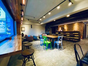 A modern interior with a bar area, seating arrangements, and a kitchen visible in the background. - The Upstairs (Hualien City)