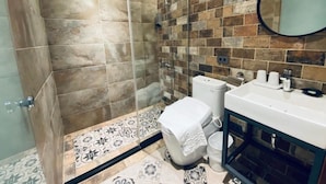 A bathroom with a shower, toilet, sink, and a mirror. - The Upstairs (Hualien City)