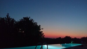 A swimming pool at dusk with a clear view of the sky and surrounding trees. - TerraMater (Noto)