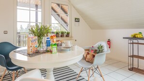 Un espace repas comprenant une table ronde, des chaises, ainsi qu’une variété de plats et de boissons.