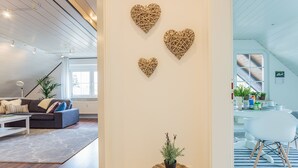 Un salon moderne avec un canapé, une table basse et des œuvres d’art décoratives au mur.