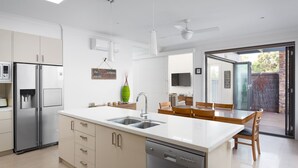 A modern kitchen with a central island, stainless steel appliances, and a dishwasher. - Douglas Hide and Sea (COWES)
