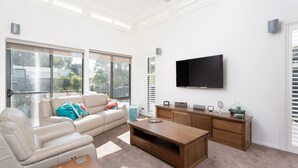 A modern living room with a sofa, coffee table, and TV. - Douglas Hide and Sea (COWES)