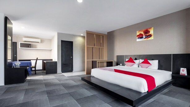Una habitación de hotel moderna con una cama grande, un escritorio y una silla.