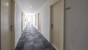 Un pasillo con puertas color crema, piso a cuadros y el número 510 en la pared.