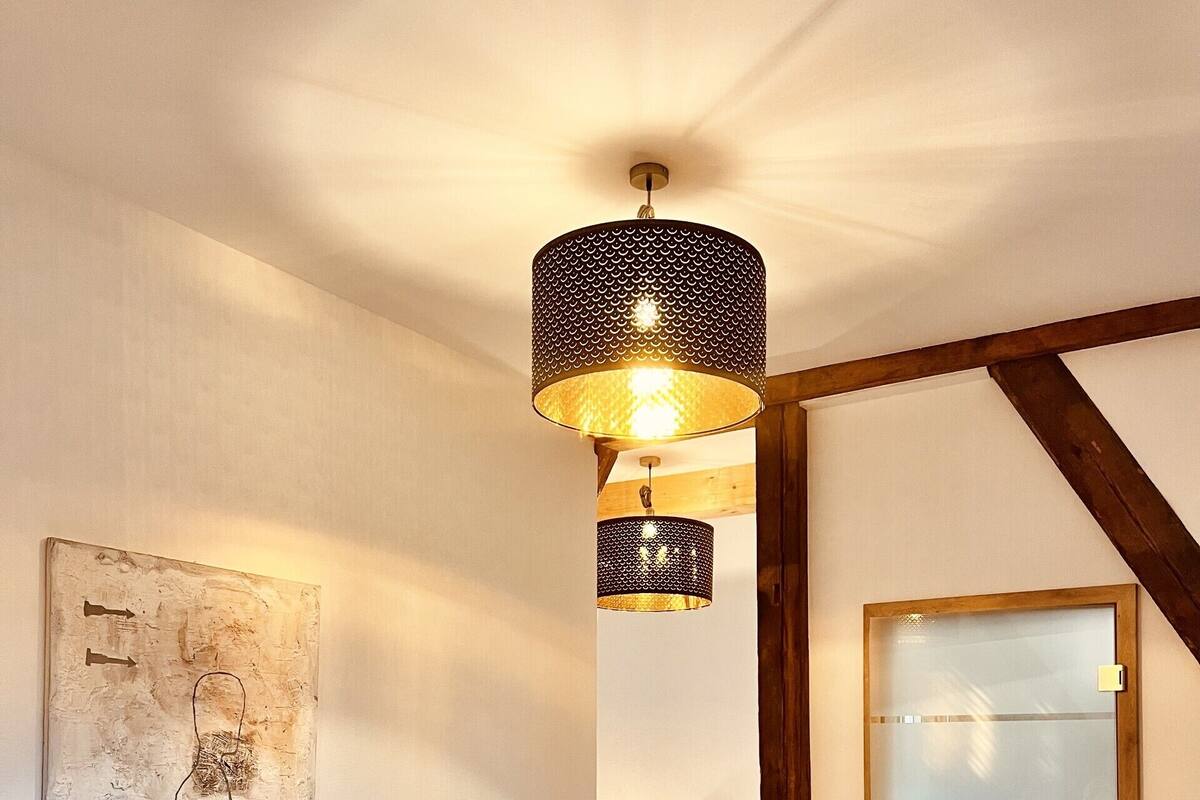 A modern living room with a sofa, a coffee table, and a unique hanging light fixture.