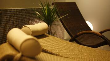 A close-up of a textured fabric surface, possibly a towel or blanket, with a rolled-up item and a plant in the background.