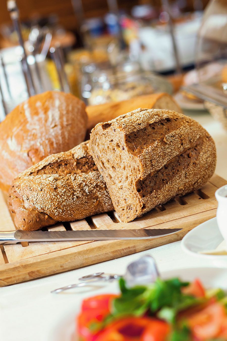 A loaf of whole grain bread on a wooden cutting board.