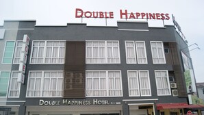 A hotel named "Double Happiness Hotel" with a modern facade, multiple windows, and a signboard. - Double Happiness Hotel (Seri Manjung)