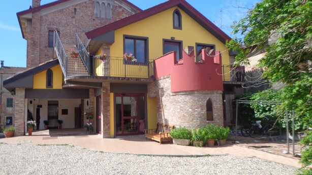A two-story building with a yellow facade and a red roof. - Ostello Le Tre Corone (Calendasco)
