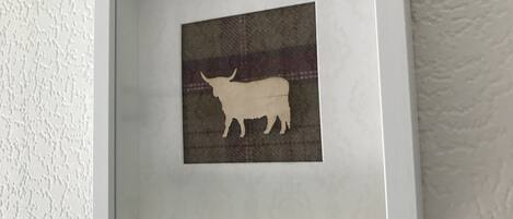 A framed artwork of a bull on a textured background.
