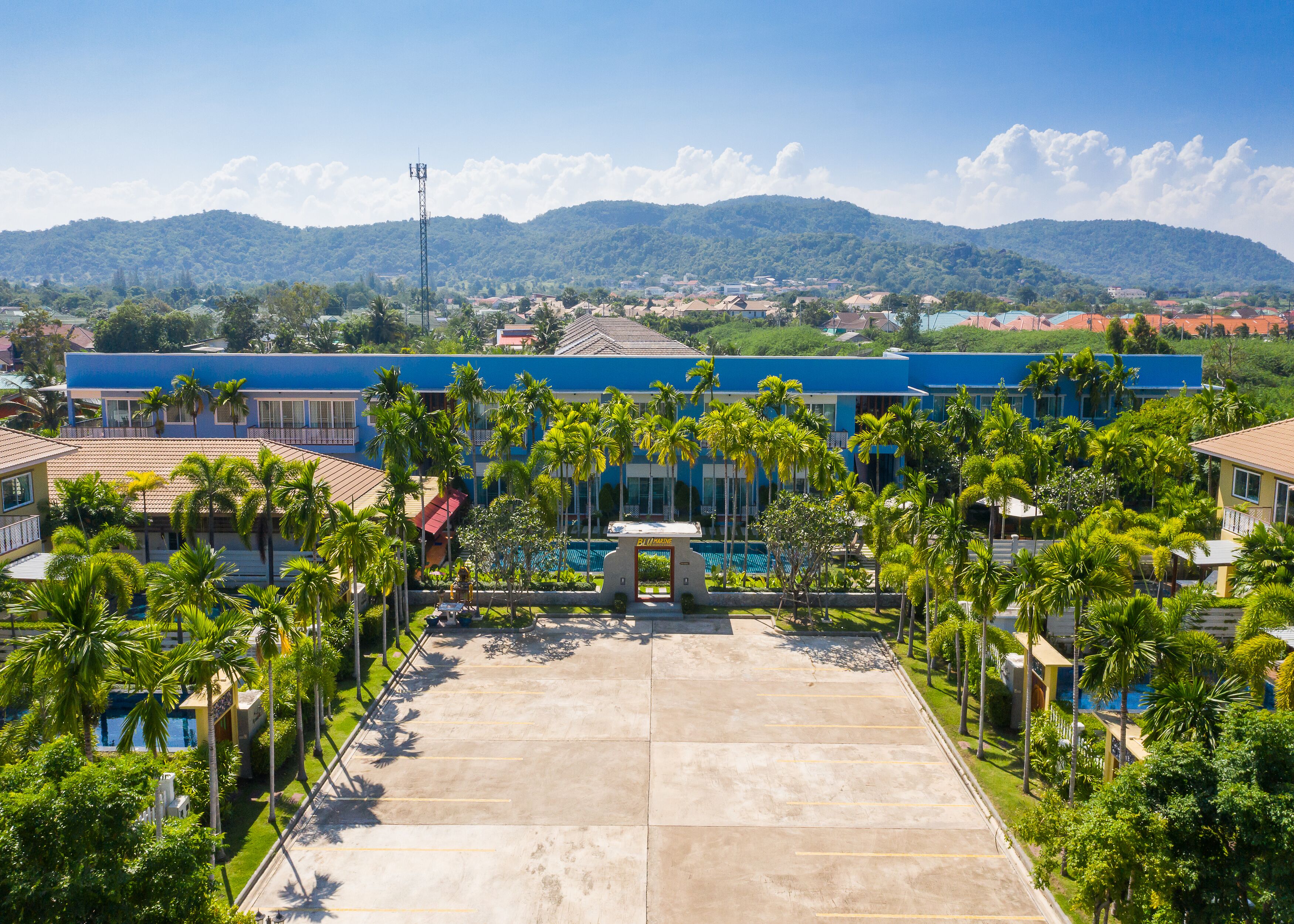 Ein Resort mit Pool, Palmen und Bergblick.