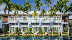 A multi-story hotel with balconies, a swimming pool, and palm trees. - Blu Marine Hua Hin Resort and Villas (Hua Hin)