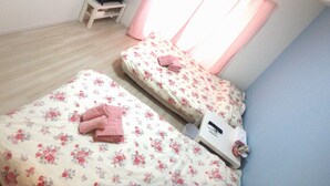 A bedroom with two beds, a TV on a small table, and a window with curtains. - YADO at Shinsaibashi Namba ExMin (Osaka)