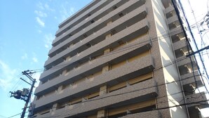 A multi-story building with a uniform brick facade, multiple balconies, and visible utility lines. - YADO at Shinsaibashi Namba ExMin (Osaka)