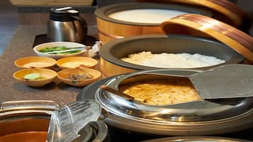 A buffet table with various food items and containers.