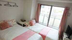 A hotel room with two beds, a small table, a clock, and a TV. - YADO at Tennouji Namba ExTen (Osaka)