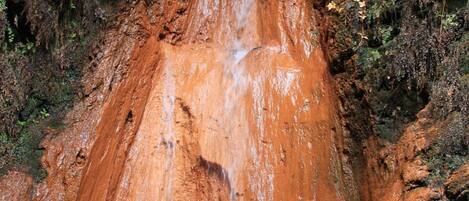 A natural rock formation with a waterfall.