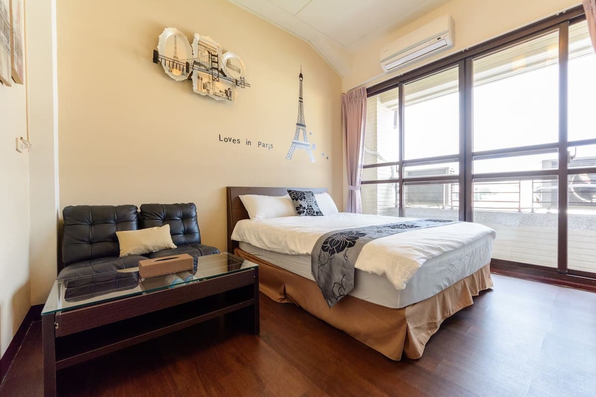 Ein Hotelzimmer mit einem Bett, einem Schlafsofa, einem Glastisch und einem großen Fenster mit Blick.